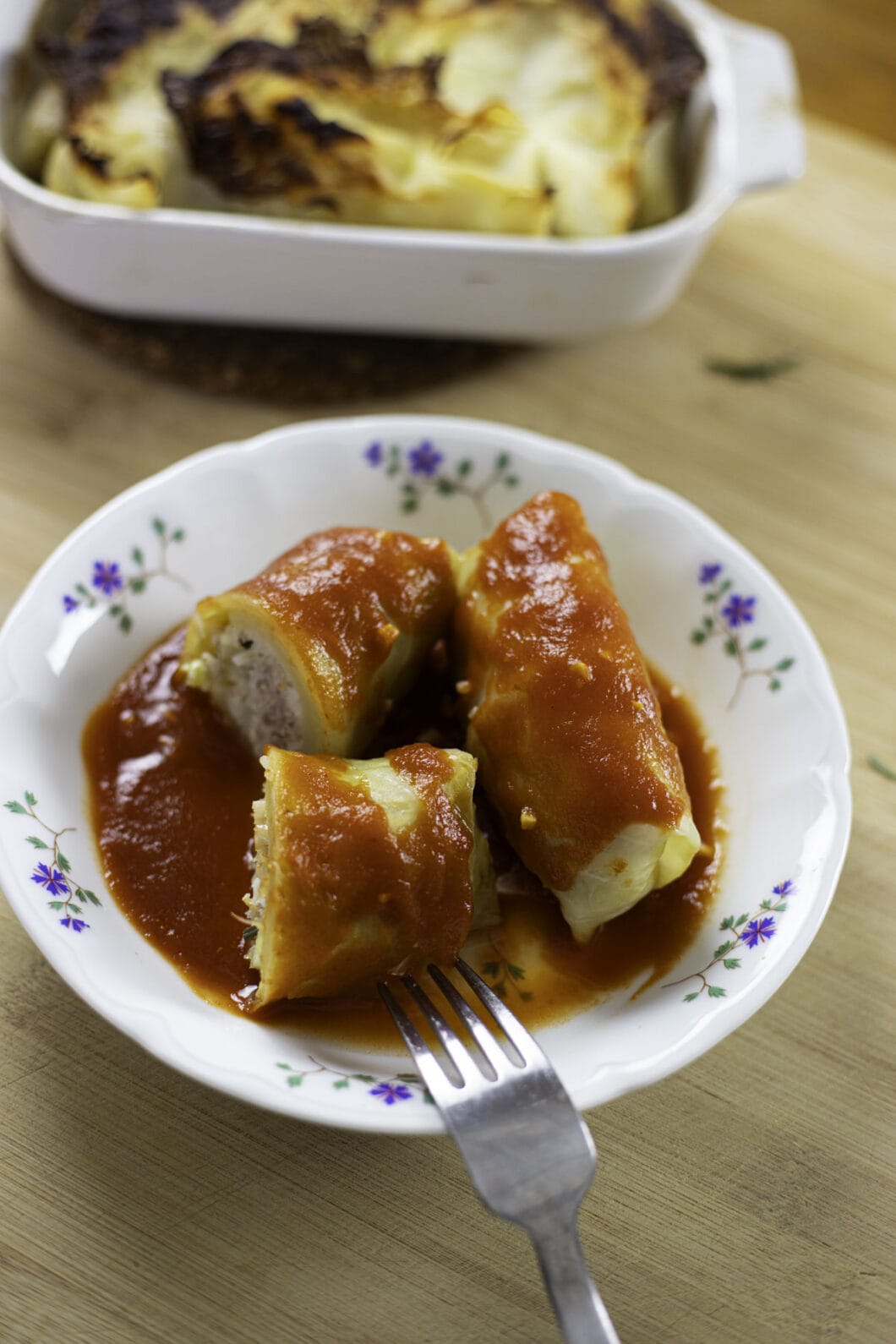 Golumpkis (stuffed cabbage rolls) in a plate with tomato sauce