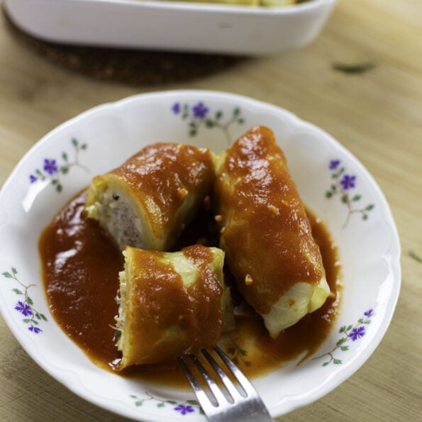 Golumpkis (stuffed cabbage rolls) in a plate with tomato sauce