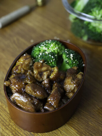 Chicken teriyaki with a glistening soy-based sauce and broccoli, in a bento with rice