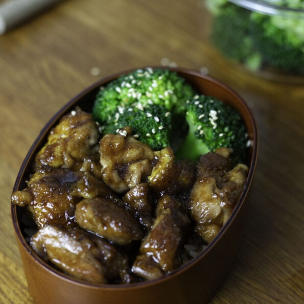 Chicken teriyaki with a glistening soy-based sauce and broccoli, in a bento with rice