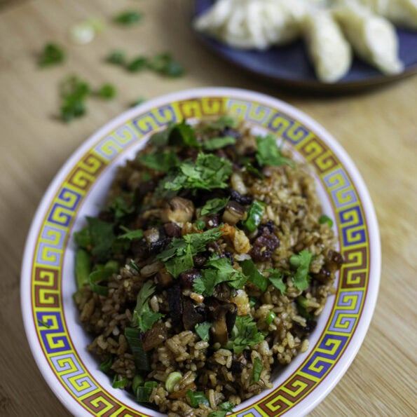 Cantonese sticky fried rice with Lap Cheong and cured pork belly, topped with cilantro leaves