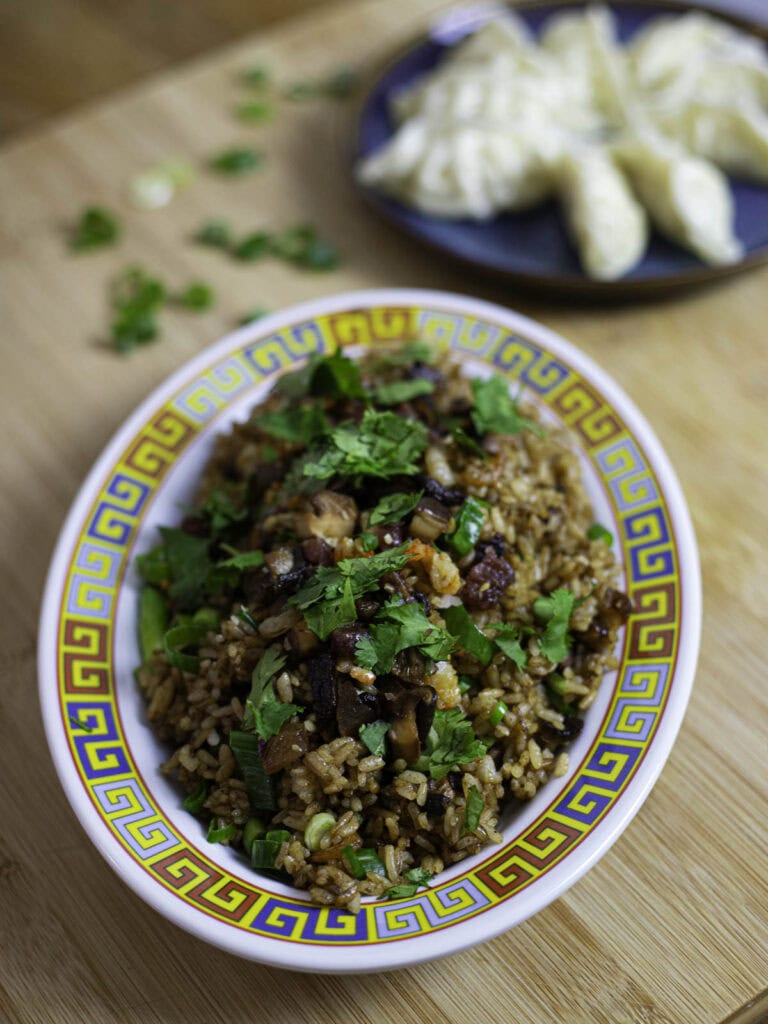 Cantonese sticky fried rice with Lap Cheong and cured pork belly, topped with cilantro leaves