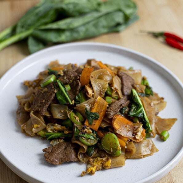 Pad See Ew, fresh wide rice noodles with a soy based sauce, carrots and Chinese broccoli (Gai Lan)