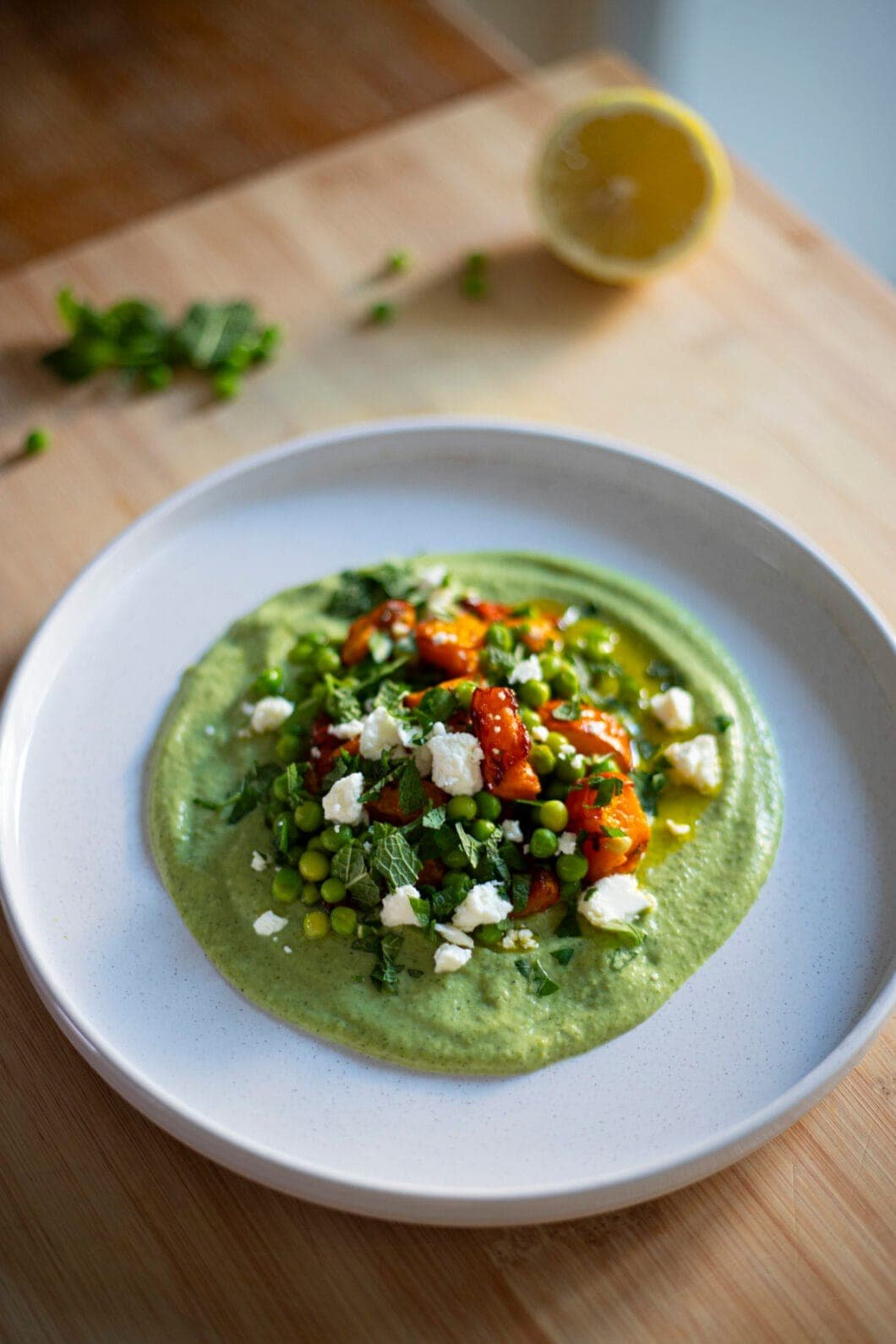Peas, squash and feta on a bed of broccoli cream, topped with mint and parsley