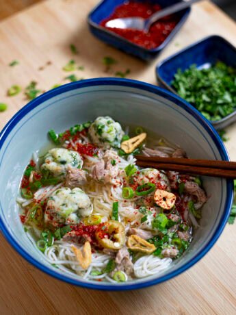 Thai fishball noodle soup with a clear broth, cilantro, green onion, garlic oil