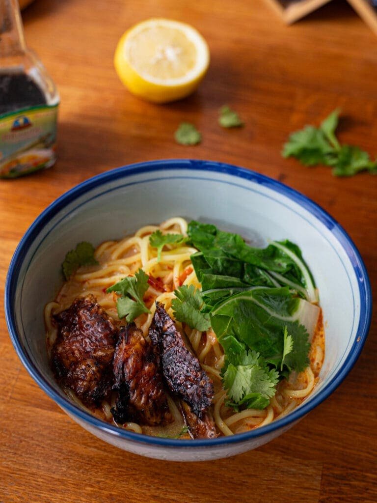 Red curry ramen with fresh noodles, cabbage, browned chicken and cilantro
