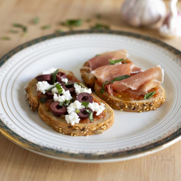 Pan con tomate two ways - one with feta cheese and slices kalamata olives, one with cured ham