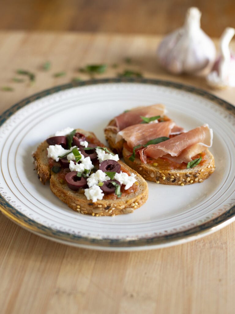 Pan con tomate two ways - one with feta cheese and slices kalamata olives, one with cured ham