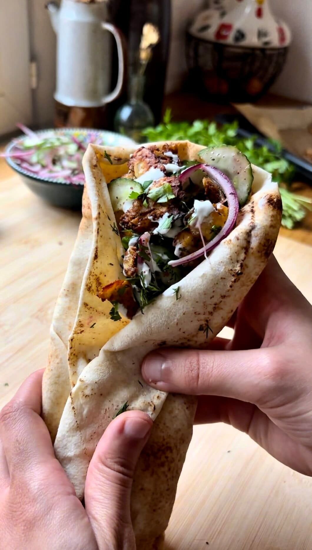 Grilled halloumi pita sandwiches with crispy cheese, fresh vegetables and creamy sauce in warm flatbread, an easy Mediterranean vegetarian lunch idea.