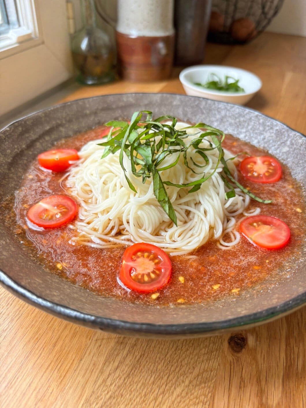 cold grated tomato soup with somen and basil and cherry tomatoes on top