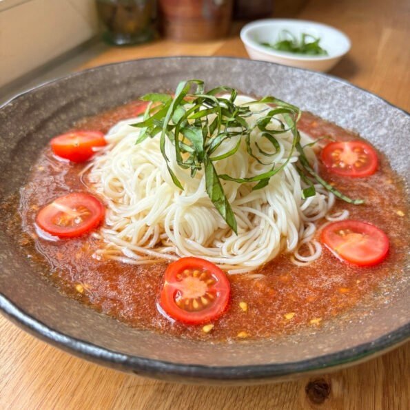 cold grated tomato soup with somen and basil and cherry tomatoes on top