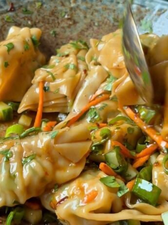 Wonton salad coated in a luscious oily sauce, topped with carrots, cucumber, cilantro, scallions