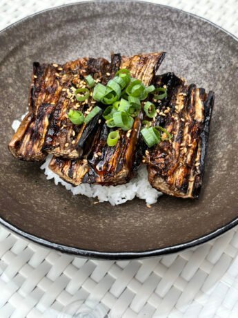 Eggplant slices with a glossy kabayaki glaze, topping Japanese short grain rice