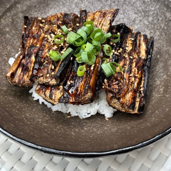 Eggplant slices with a glossy kabayaki glaze, topping Japanese short grain rice