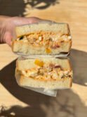 Thick sandwich bread filled with a creamy egg salad that comprises tomatoes, bacon and chilies
