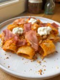 Mezzi paccheri pasta in pesto rosso topped with straciatella, pangrattato and parma ham
