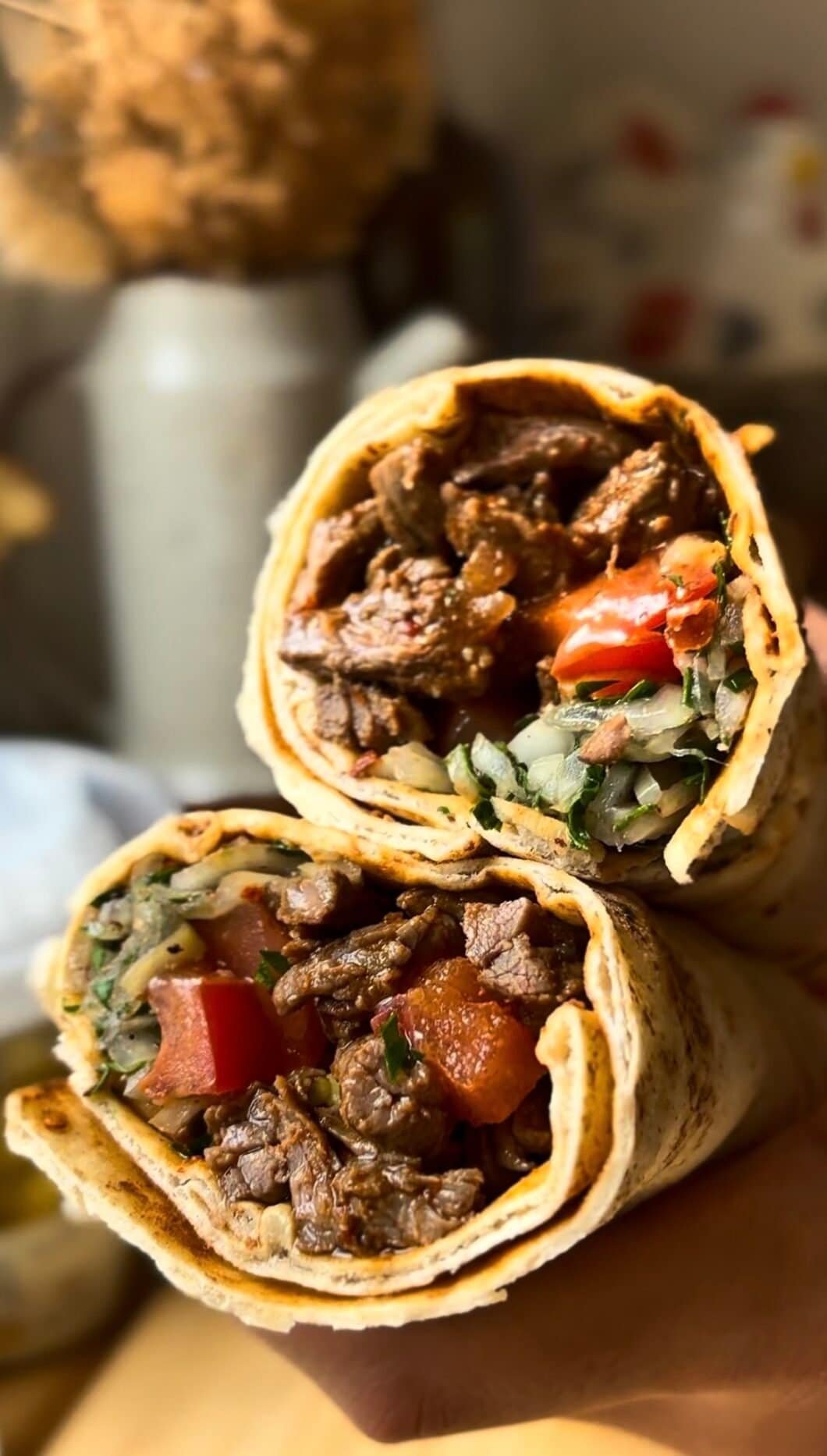 Beef tantuni in a lavash bread with tomatoes, onion and sumac, pickled peppers, parsley