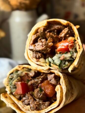 Beef tantuni in a lavash bread with tomatoes, onion and sumac, pickled peppers, parsley